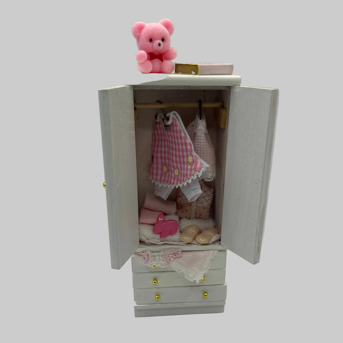 Doll house filled child's wardrobe